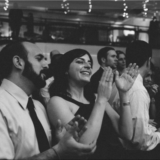 Guests clapping and smiling at elegant black and white wedding reception in Boston.