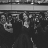 Black and white wedding guests dancing joyfully at a lively Boston celebration.