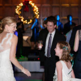 Bride dancing with flower girl at festive Harvard Club Boston holiday wedding reception.
