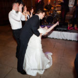 Bride and groom share joyful first dance surrounded by cheering guests at elegant Harvard Club wedding.