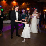 Father and daughter dancing joyfully at elegant holiday wedding reception in Boston.