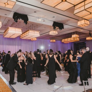 Elegant wedding reception at InterContinental Boston with guests dancing under warm golden ballroom lighting.