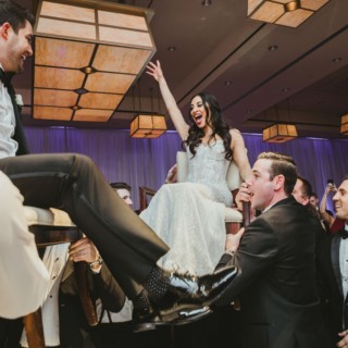 Bride and groom lifted during joyful Jewish Hora dance at InterContinental Boston wedding celebration.