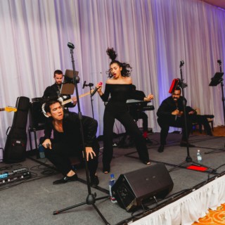 Energetic live wedding band performing at InterContinental Boston with vibrant lighting and passionate singers.