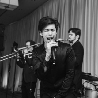 Black and white live band performance with passionate singer and musicians at Boston wedding.