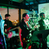 Live band performing at elegant Boston event with colorful lighting and passionate vocalists.