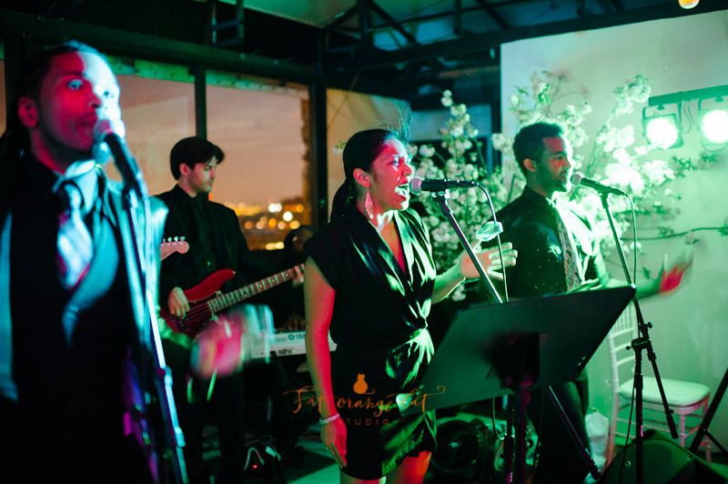 Romantic rooftop wedding reception with golden lanterns, city skyline views, and elegant floral decor.