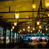 Romantic rooftop wedding reception with golden lanterns, city skyline views, and elegant floral decor.