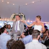 Bride and groom lifted during joyful hora dance at Pelham House wedding in Dennis Port, MA.