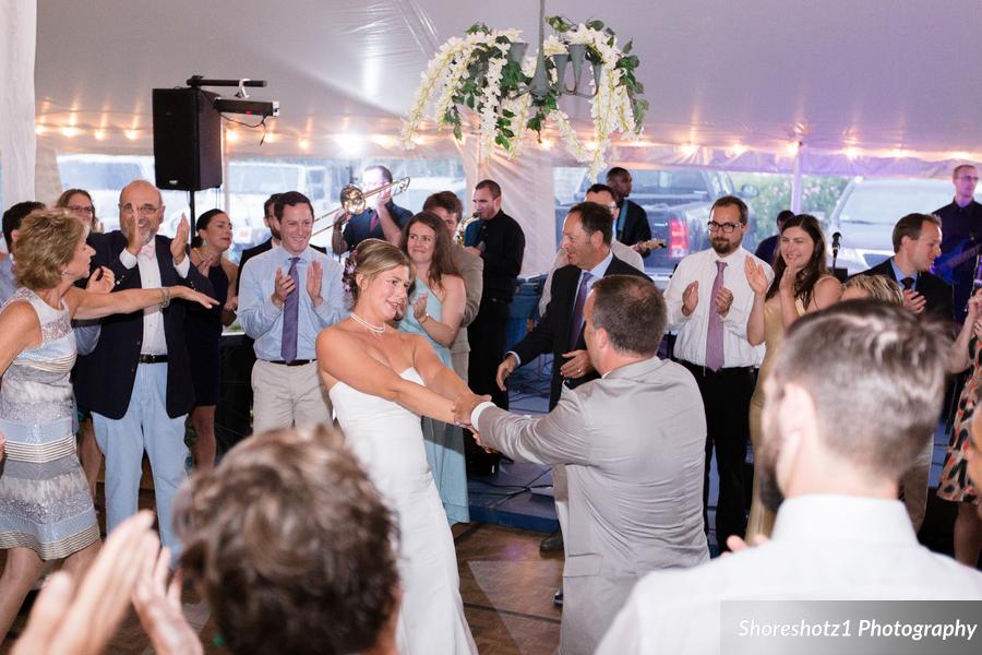 Bride and groom lifted during joyful hora dance at Pelham House wedding in Dennis Port, MA.