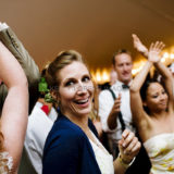 Smiling woman dancing at joyful wedding reception in Westerly, Rhode Island.