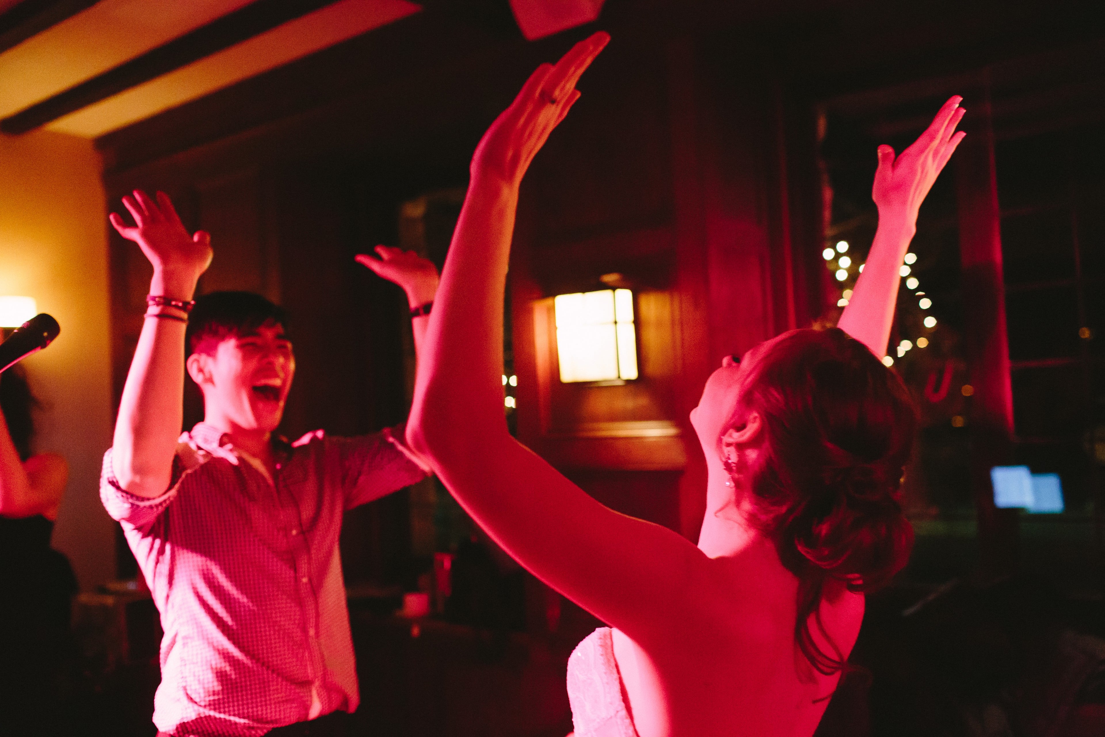 Couple dancing joyfully under warm lights at Willowdale Estate wedding reception in Ipswich, Massachusetts.