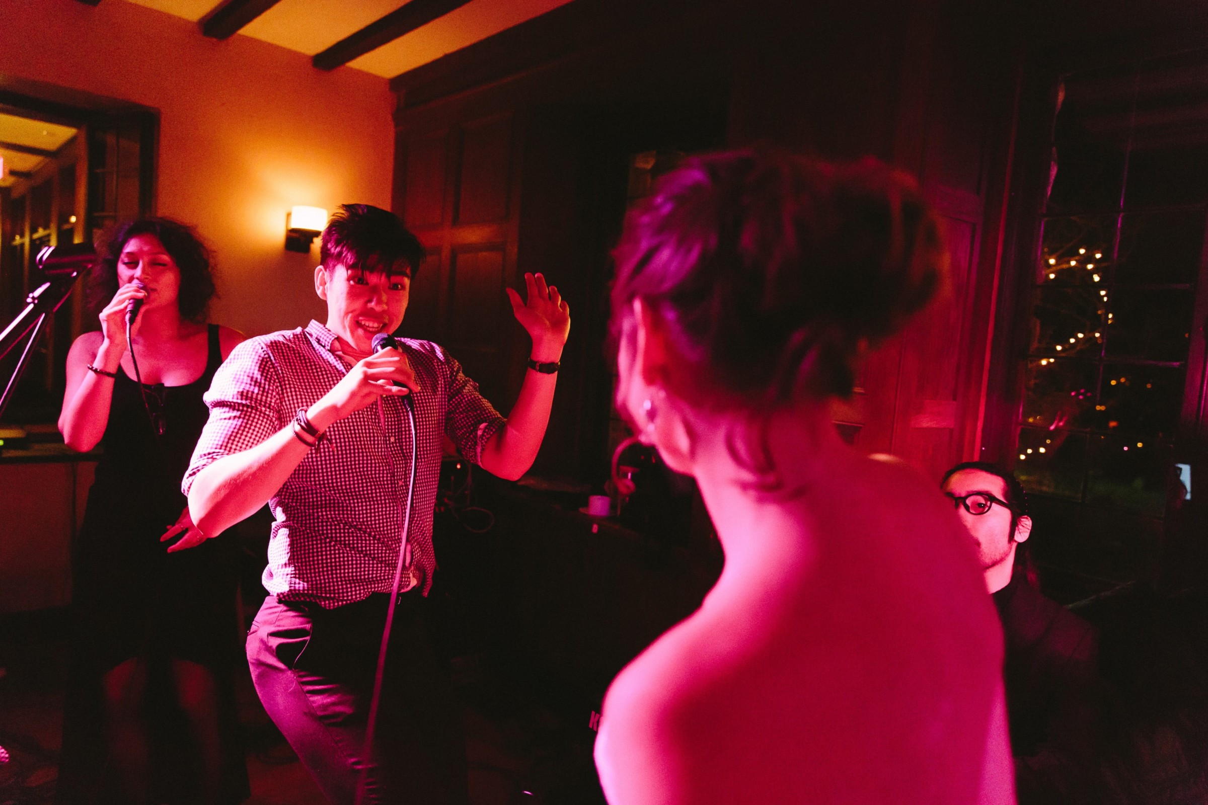 Singer performs up close with guest during lively wedding celebration at Willowdale Estate in Ipswich.