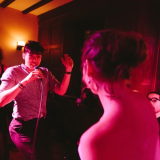 Singer performs up close with guest during lively wedding celebration at Willowdale Estate in Ipswich.