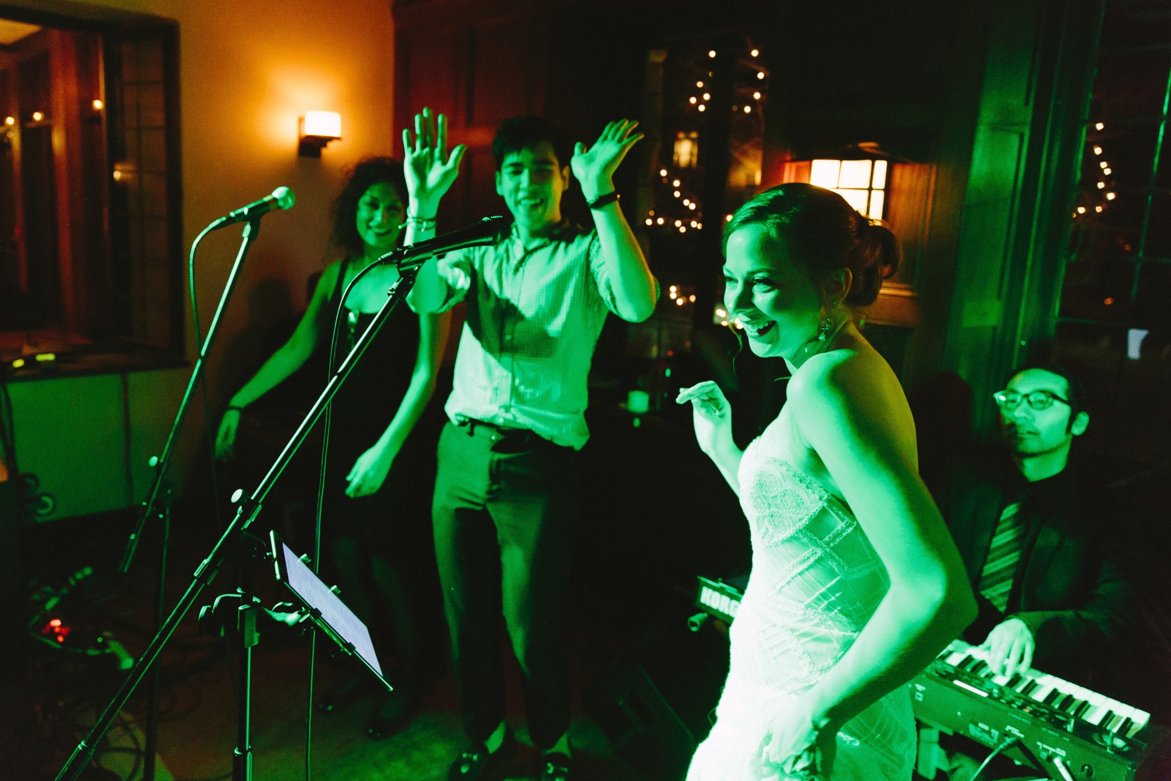 Bride dancing joyfully with guests under green lights at Willowdale Estate wedding reception.