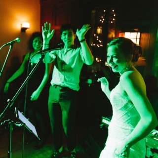 Bride dancing joyfully with guests under green lights at Willowdale Estate wedding reception.