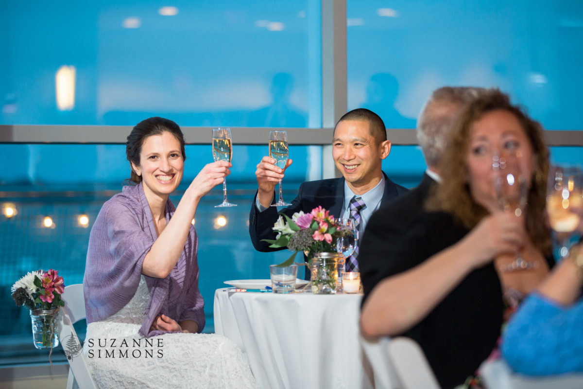 Bride and groom share a joyful champagne toast at elegant Ocean Gateway wedding in Portland, Maine.