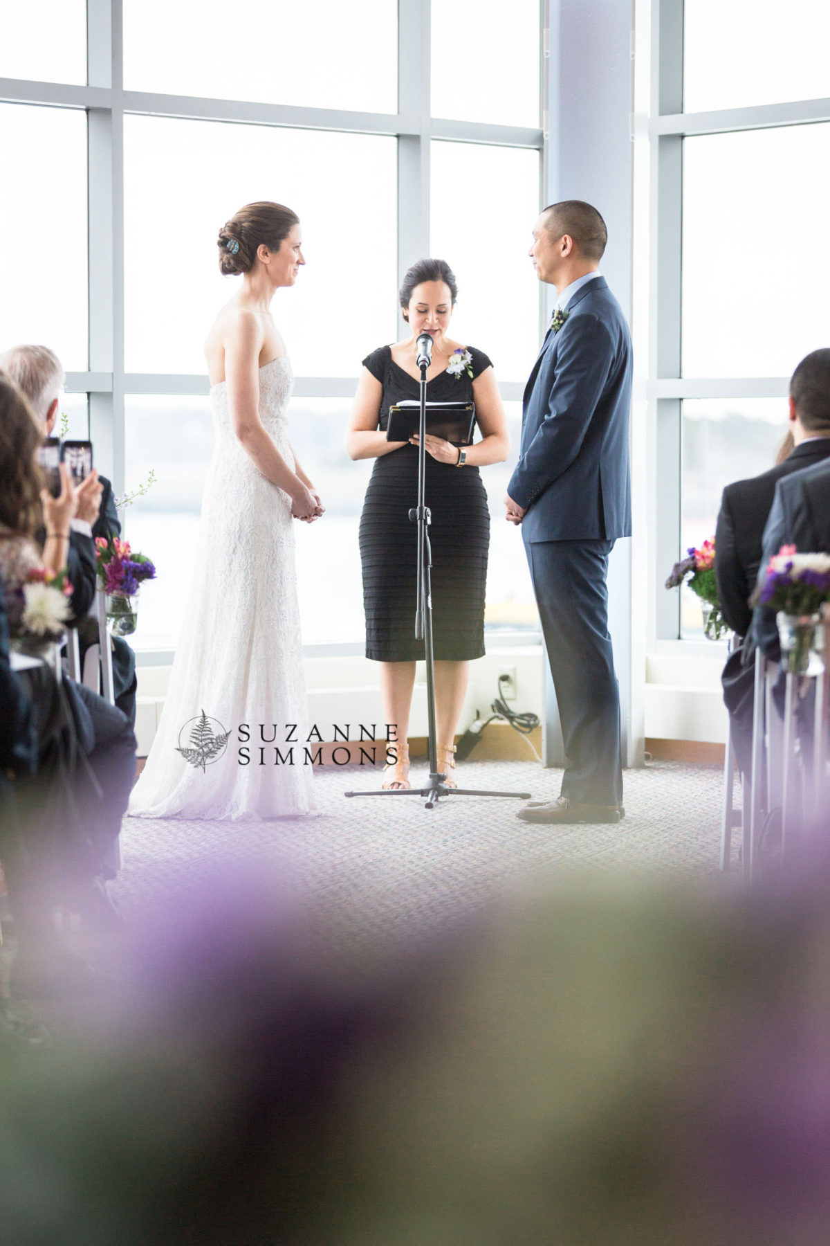 Bride and groom exchange vows at a sunlit waterfront wedding in Portland, Maine.