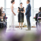 Bride and groom exchange vows at a sunlit waterfront wedding in Portland, Maine.