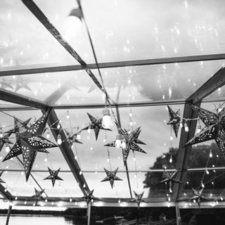 Lakeside boathouse ceiling with hanging star lights and reflections creating a dreamy, festive atmosphere.