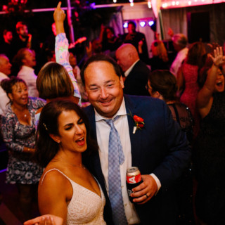 Bride and groom dancing joyfully at lively Maine Boathouse wedding reception in South Freeport.