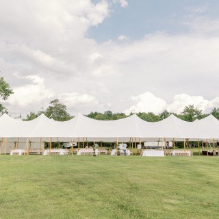 Elegant white wedding tent on green field at Abenakee Club in Biddeford Pool, Maine.