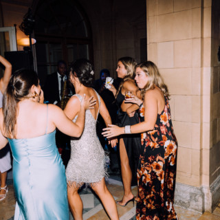 Elegant wedding guests dancing joyfully on the marble floor at Aldrich Mansion in Warwick.