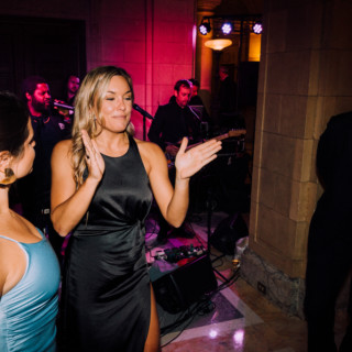 Elegant wedding reception at Aldrich Mansion with guests enjoying live music and vibrant lighting.