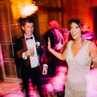 Elegant couple dancing amid colorful lights at Aldrich Mansion wedding reception in Warwick, Rhode Island.