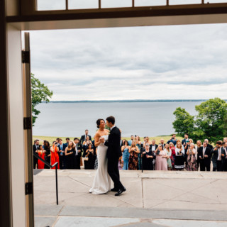 Bride and groom share first dance at Aldrich Mansion overlooking lake in Warwick, Rhode Island.