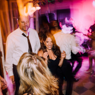 Guests dancing joyfully under colorful lights at Aldrich Mansion wedding reception in Warwick, Rhode Island.