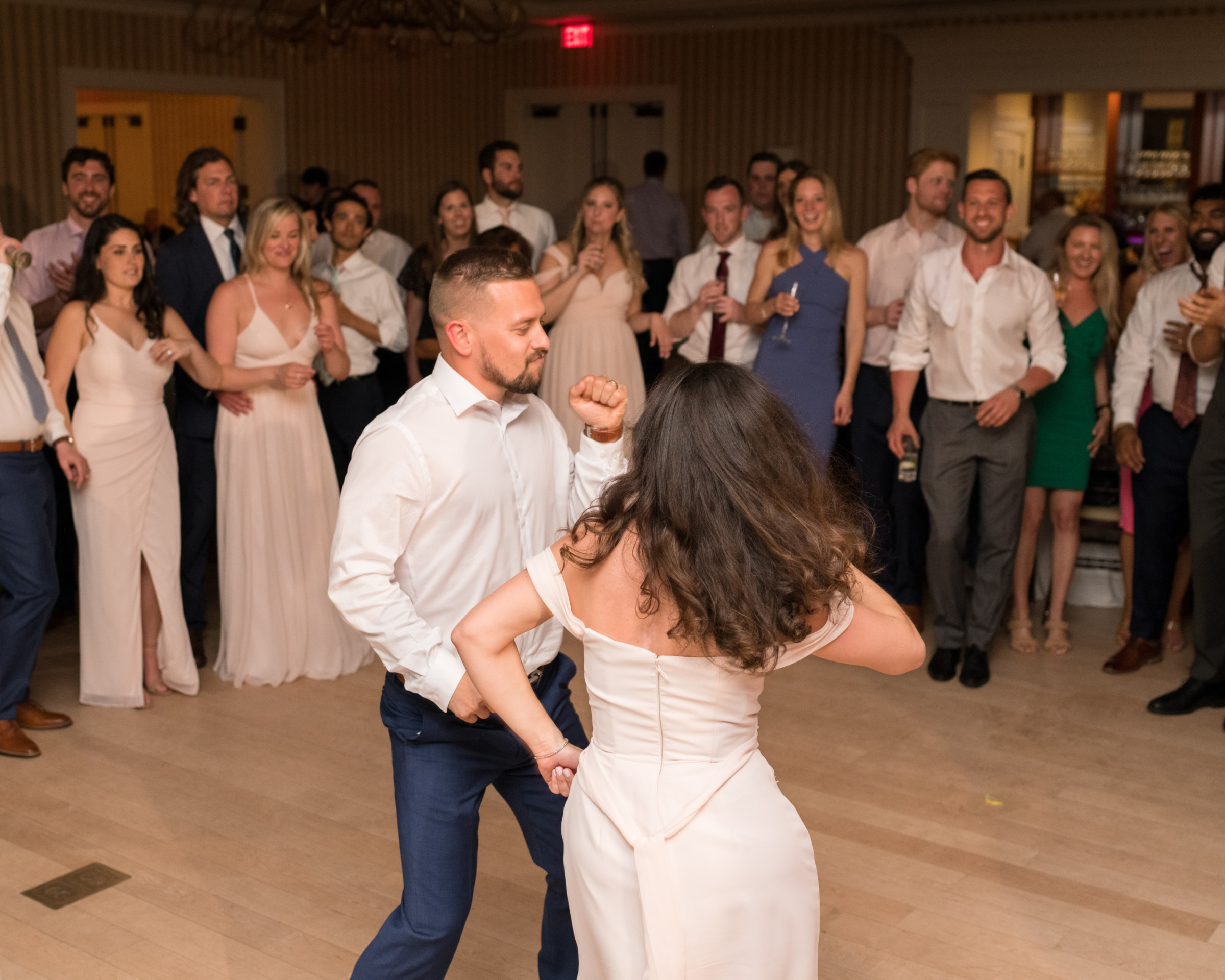 Couple dancing joyfully at Beauport Hotel wedding in Gloucester surrounded by smiling guests.