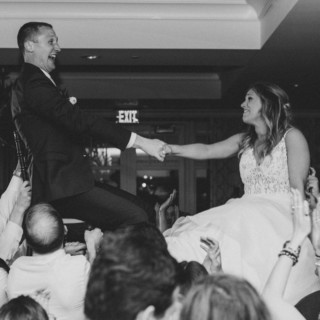 Bride and groom lifted during joyful hora dance at elegant Beauport wedding in Gloucester, Massachusetts.