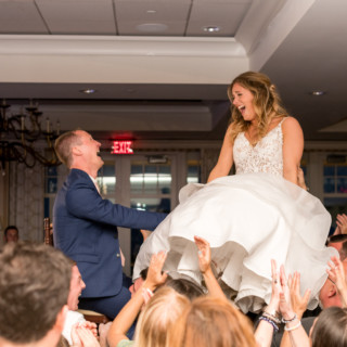 Bride and groom lifted on chairs during joyful Beauport Hotel wedding celebration in Gloucester, MA.