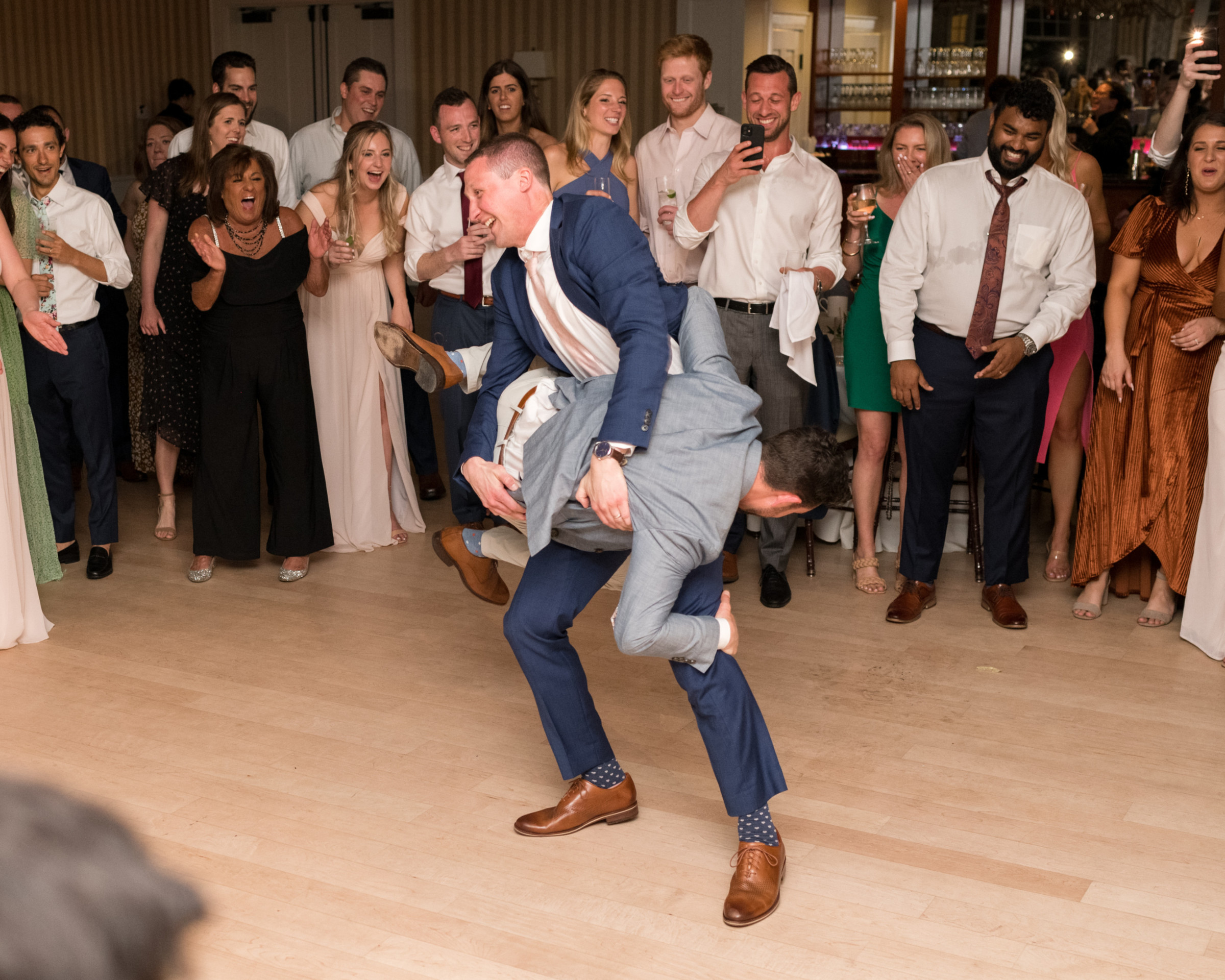 Two grooms joyfully dancing at Beauport wedding reception in Gloucester, Massachusetts.