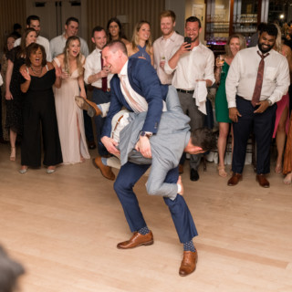 Two grooms joyfully dancing at Beauport wedding reception in Gloucester, Massachusetts.