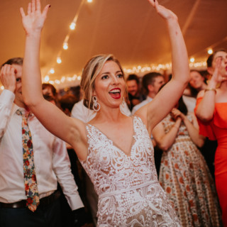 Bride dancing joyfully under string lights at Toad Hill Farm wedding in Franconia, New Hampshire.