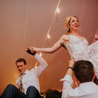 Bride and groom lifted on chairs during joyful Hora dance at Toad Hill Farm wedding.