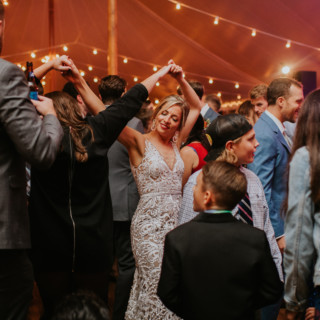 Bride dancing joyfully under glowing string lights at Toad Hill Farm wedding in Franconia, NH.
