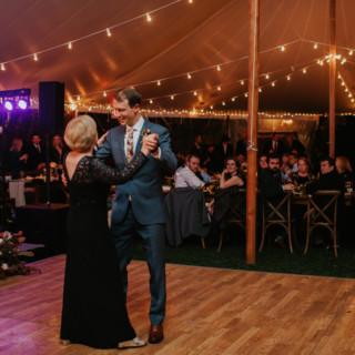 Groom dancing with his mother under string lights at Toad Hill Farm wedding reception.