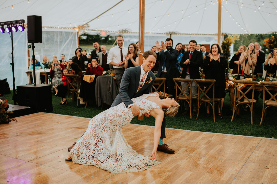 Bride and groom share a joyful first dance under string lights at Toad Hill Farm wedding.