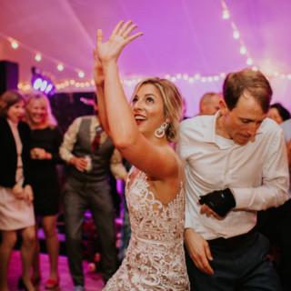 Bride and groom dancing joyfully under string lights at Toad Hill Farm wedding in Franconia.
