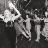 Women dancing joyfully at rustic barn wedding reception in New Gloucester, Maine.
