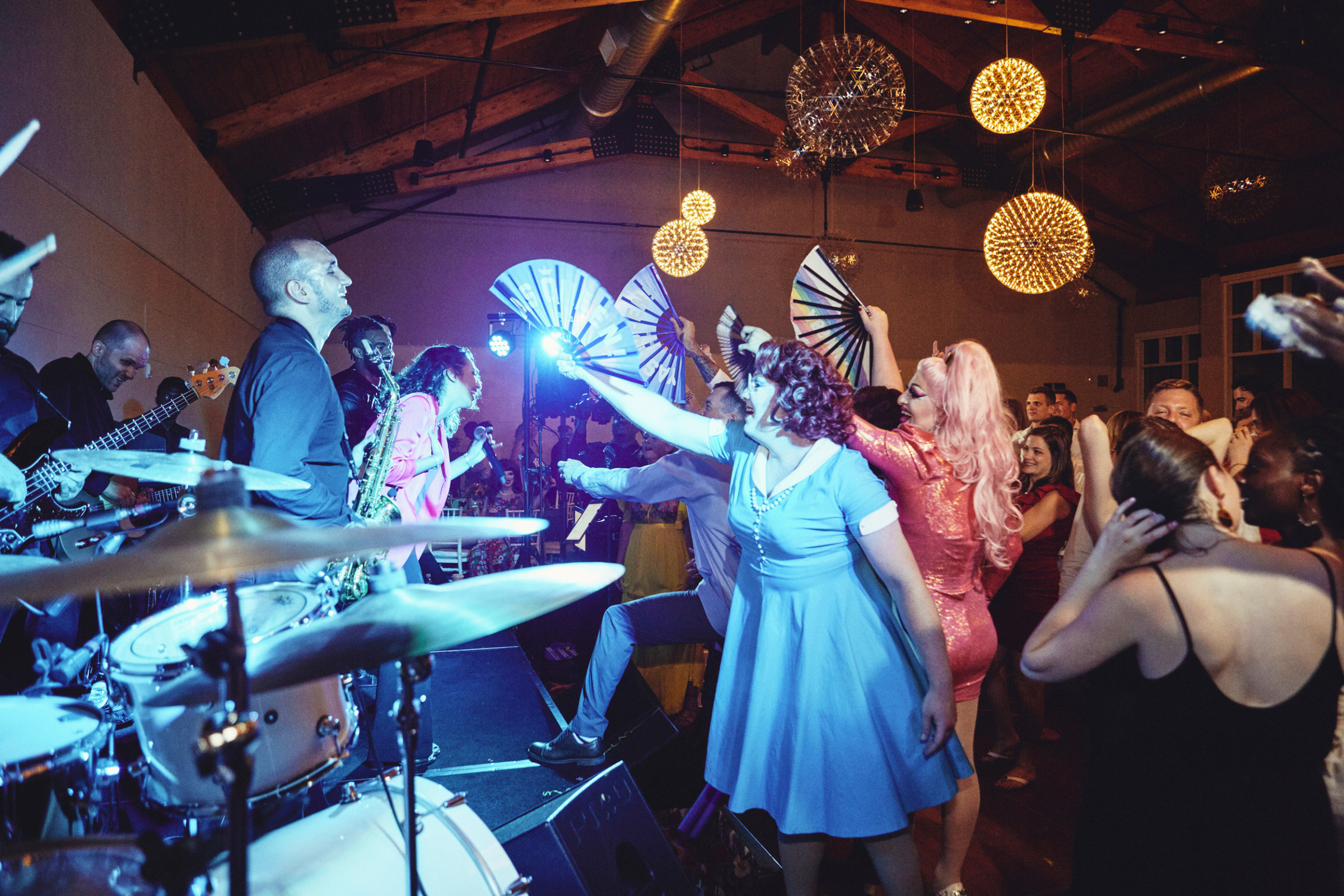 Live band performing at vibrant indoor party with dancing guests and colorful festive lighting