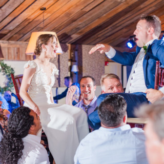 Bride and groom lifted during joyful Hora dance at rustic Gibbet Hill wedding in Groton.