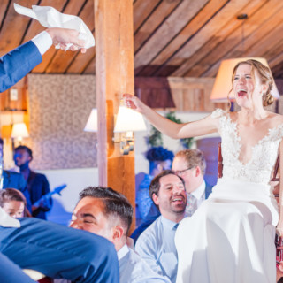 Bride and groom lifted during joyful Hora dance at Gibbet Hill wedding in Groton, Massachusetts.