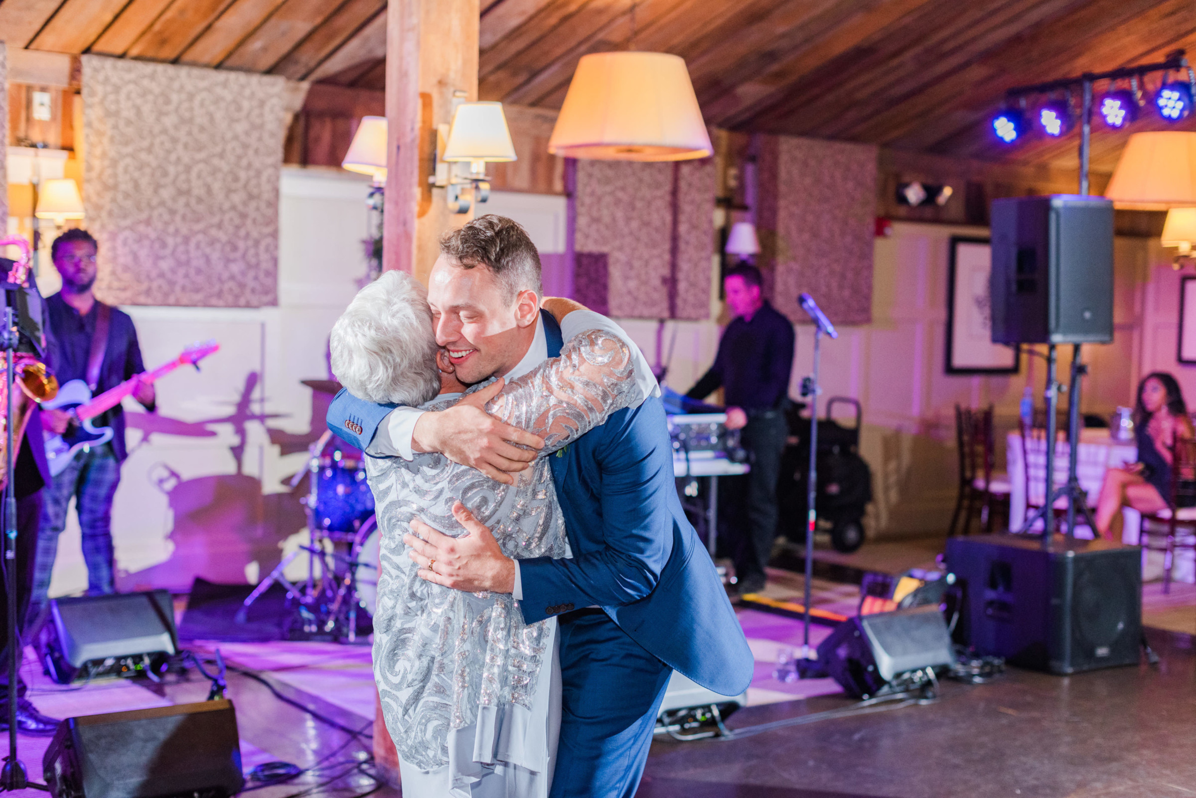Grandmother and grandson share a joyful embrace on the dance floor at a Gibbet Hill wedding.