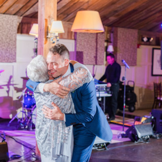 Grandmother and grandson share a joyful embrace on the dance floor at a Gibbet Hill wedding.
