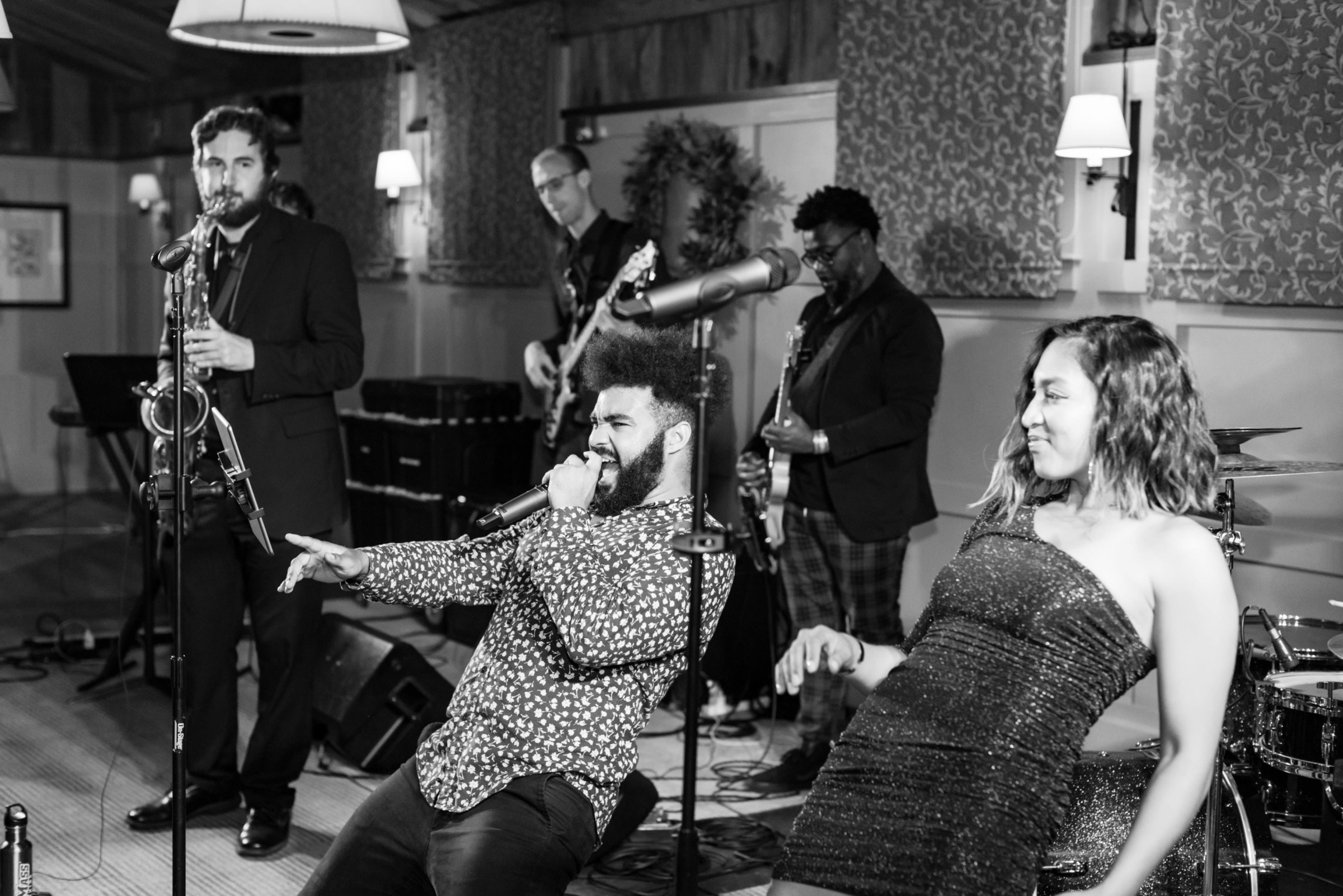 Black and white photo of a soulful live band performing with singer, dancer, and musicians.