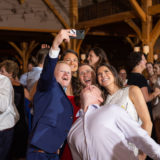 Smiling wedding guests take a joyful selfie at rustic Harrington Farm celebration in Princeton, MA.